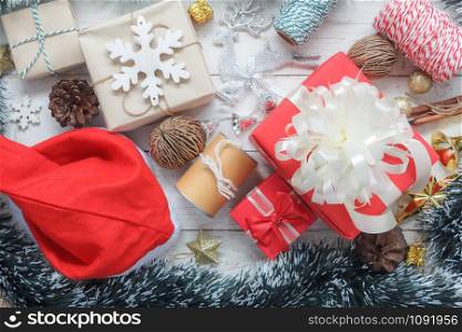 Above view of Merry Christmas decorations & Happy new year ornaments concept.Essential difference objects on modern rustic wood white background at home studio office desk.Party items on floor.