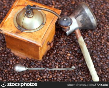 above view of retro manual coffee grinder and copper pot on many roasted coffee beans