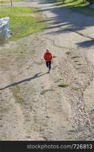 Above View Of Senior Man Jogging Through Park in a sunny day
