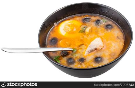 above view of Solyanka russian traditional spicy and sour soup with fish in bowl with spoon isolated on white background