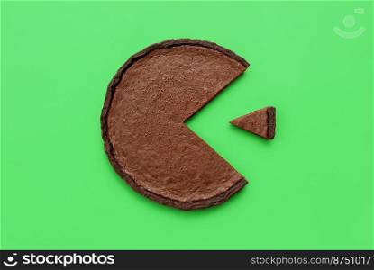 Above view with a chocolate tart minimalist on a green table. Pie chart concept with a small slice of cake next to a bigger piece.