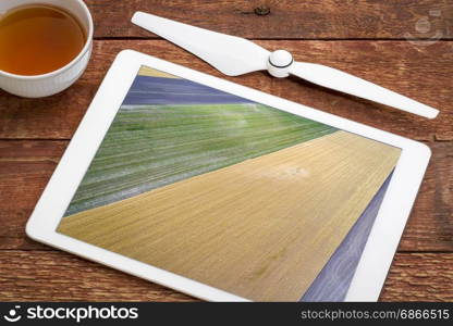 abstract aerial view of rural Nebraska - plowed, wheat and corn fields, reviewing image on a digital tablet