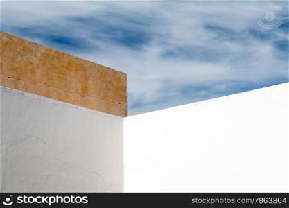 Abstract Angular White Wall with White Clouds and Blue Sky