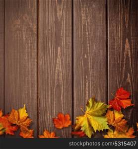 Abstract autumnal backgrounds. Fall maple leaves over vintage wooden desk