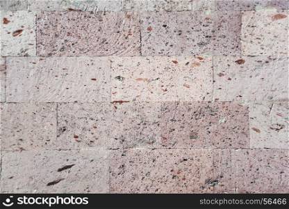 Abstract background: a wall of natural pink tuff