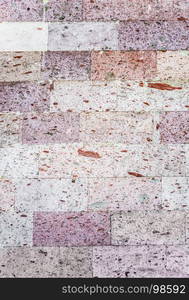 Abstract background: a wall of natural pink tuff stone