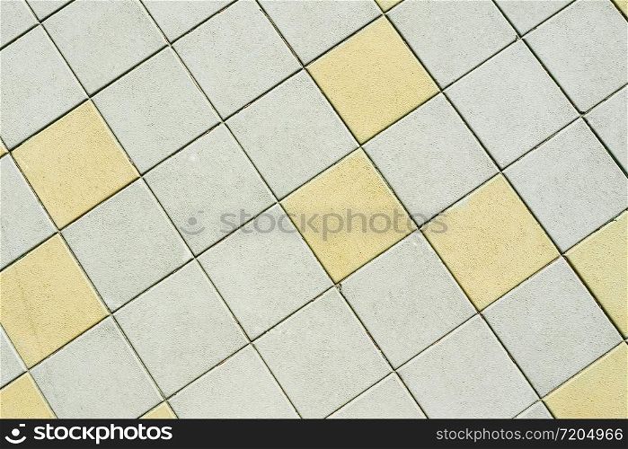 Abstract background and texture of a street square tile. Bridge. Gray and yellow squares.