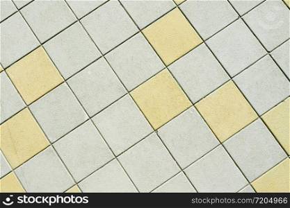 Abstract background and texture of a street square tile. Bridge. Gray and yellow squares.