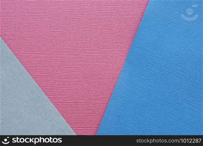 Abstract background and texture of several sheets of blue gray and burgundy paper in different shades.
