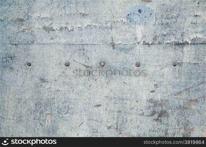 abstract background consisting of weathered board with old blue paint and bolts