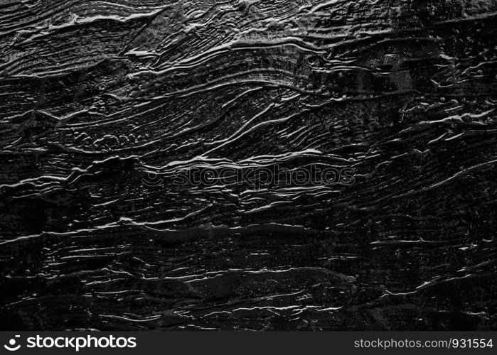 Abstract background from black rock texture plate decorated on wall. Dark backdrop.