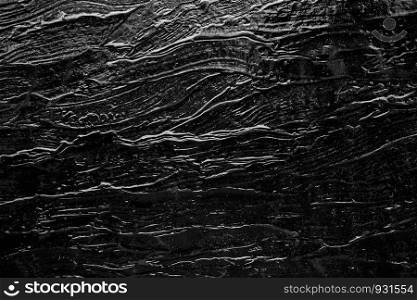 Abstract background from black rock texture plate decorated on wall. Dark backdrop.