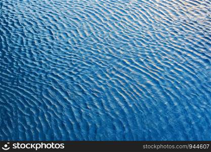 Abstract background from water wave in pool with sunlight. Travel and summer background concept. Blue backdrop.