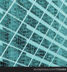Abstract background image of blur exterior building with reflection on glass window. Green monochrome image