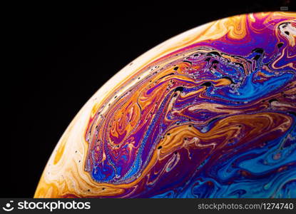 Abstract background made from soap bubble reflecting light. Rainbow soap bubble on a dark background.. Abstract background made from soap bubble reflecting light