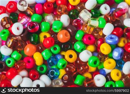 Abstract background of close up varicolored small beads. The beads background