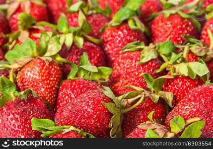 Abstract background of red strawberries with green tails