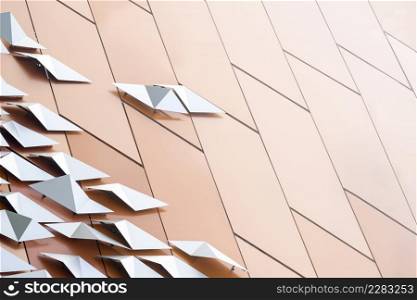 Abstract background of stainless steel plates on brown aluminum composite tiles wall decoration with gradient light on surface