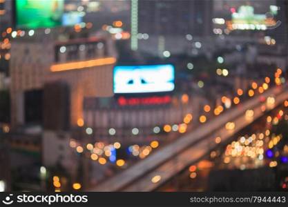 Abstract background of the night light trails with the modern building and traffic on highway, shallow depth of focus