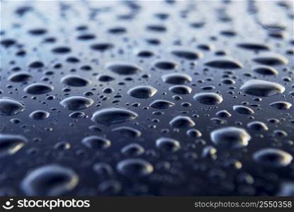 Abstract background of water drops on a blue metal surface