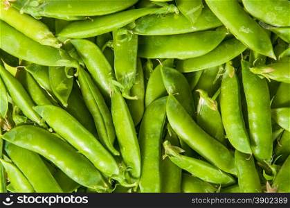 Abstract background of young green peas in the pod