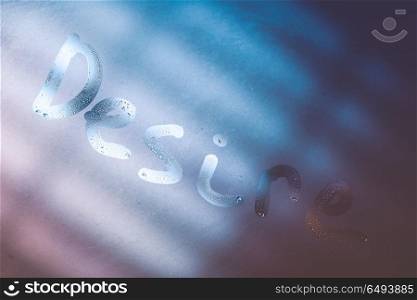 Abstract background, written word desire on a misted window at night, happy Valentine day, winter holiday of romance, passion, lust, desire and love . Desire of love concept