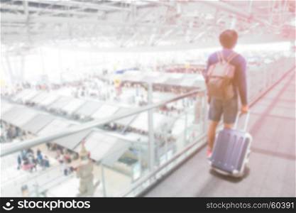 Abstract blur airport interior with traveler dragging luggage