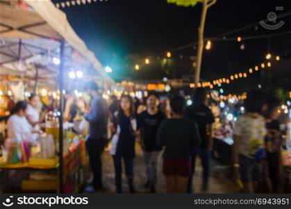 abstract blur people walking food stall at night market festival for background usage.