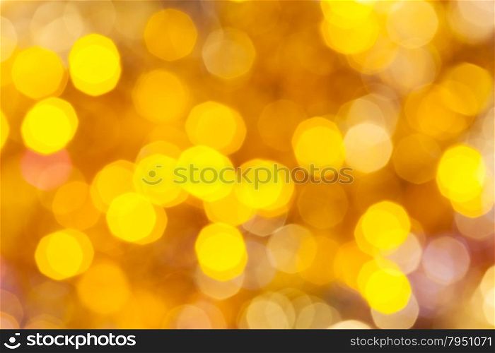 abstract blurred background - colorful yellow shimmering Christmas lights of electric garlands on Xmas tree