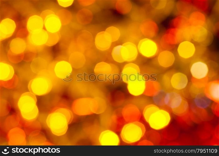 abstract blurred background - dark yellow and red flickering Christmas lights of electric garlands on Xmas tree