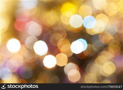 abstract blurred background - light brown shimmering Christmas lights bokeh of electric garlands on Xmas tree