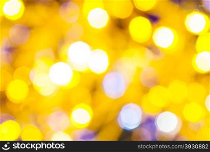 abstract blurred background - light yellow and violet flickering Christmas lights bokeh of electric garlands on Xmas tree