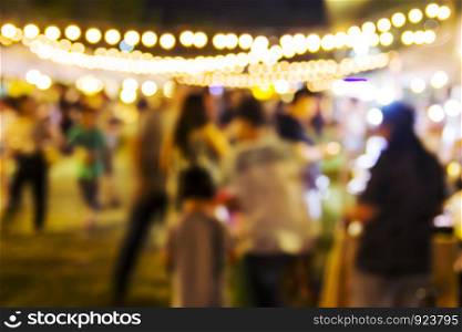Abstract blurred background of people shopping at night festival