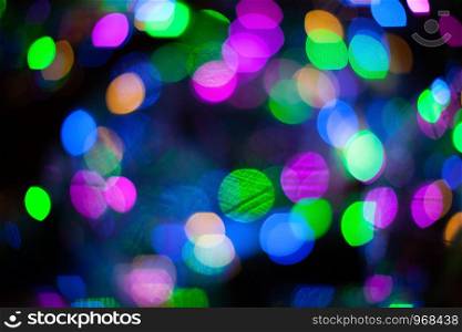 Abstract blurred background with numerous colourful bright festive bokeh. Texture with copy space for text. Celebration, holidays concept. Horizontal.