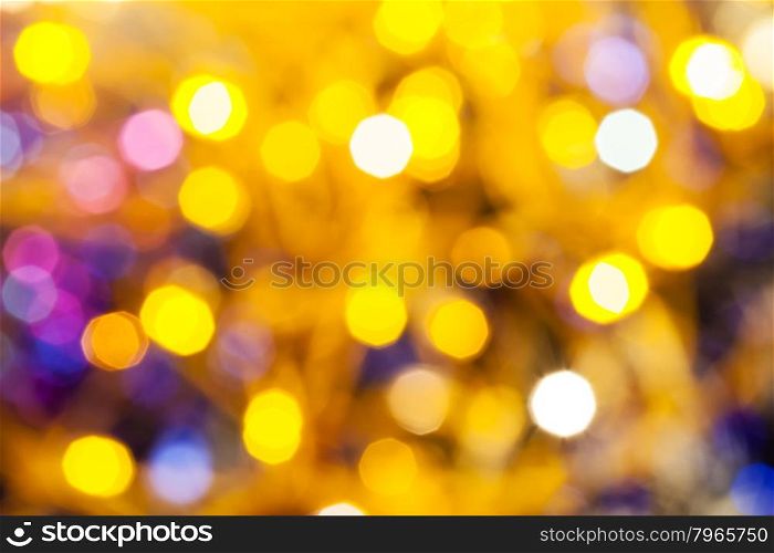 abstract blurred background - yellow and pink shimmering Christmas lights bokeh of electric garlands on Xmas tree
