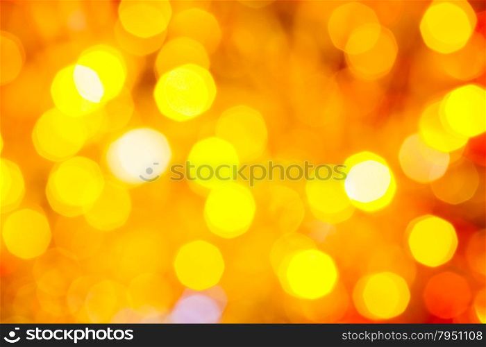 abstract blurred background - yellow and red shimmering Christmas lights of electric garlands on Xmas tree