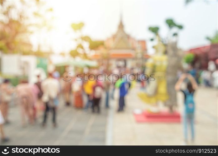 Abstract blurred image, crowd of tourists around front entrance of the Ordination Hall at Wat Arun temple. Bangkok, Thailand.