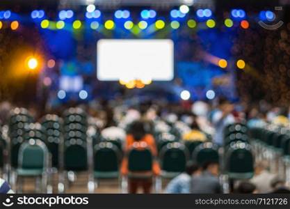 Abstract blurred photo of conference hall or seminar room in Exhibition Center with speakers on the stage and attendee background, seminar and study concept