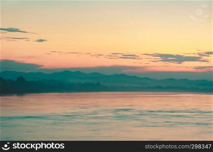 Abstract blurred sunrise of nature sea landscape with mountain background. Filtered color image.