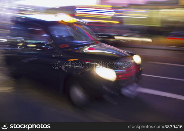 Abstract blurry image of a London taxi cab driving on a street.