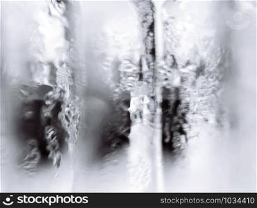 Abstract blurry wet misty glass monotone white and gray colour background with high contrast light