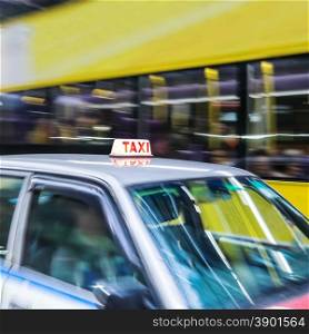Abstract cityscape blurred background with taxi car and public bus at city street. Hong Kong