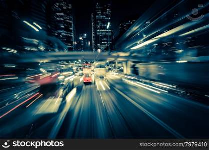 Abstract cityscape traffic background with motion blur, art toning. Moving through modern city street with illuminated skyscrapers. Hong Kong