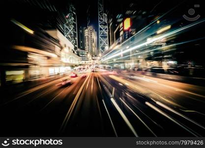 Abstract cityscape traffic background with motion blur, art toning. Moving through modern city street with illuminated skyscrapers. Hong Kong
