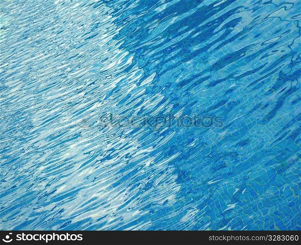 Abstract composition of blue pool water ripples.