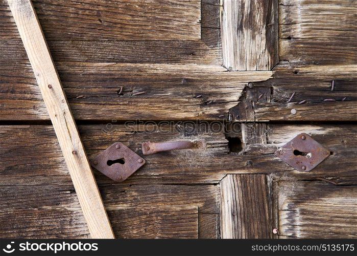 abstract cross brass brown knocker in a closed wood door albizzate varese italy