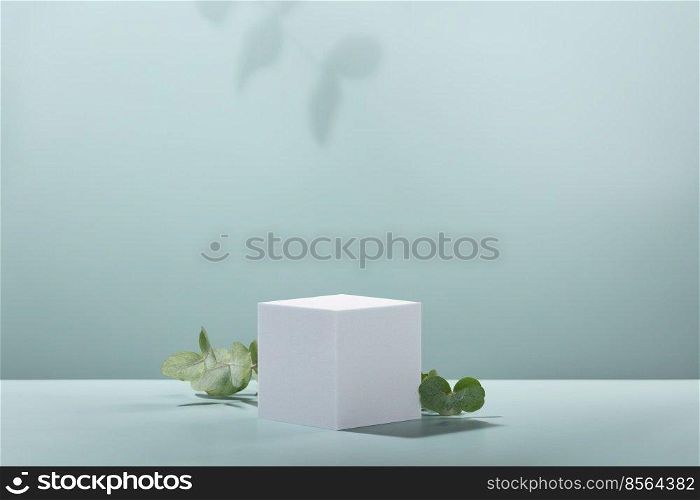 Abstract empty white podium cube with eucalyptus leaves and shadows on blue background. Mock up stand for product presentation. 3D Render. Minimal concept. Advertising template