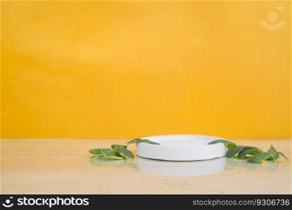 Abstract empty white podium with leaves on yellow background