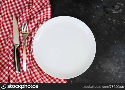 Abstract food background - empty white plate with napkin and cutlery. Abstract food background