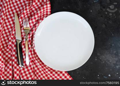 Abstract food background - empty white plate with napkin and cutlery. Abstract food background